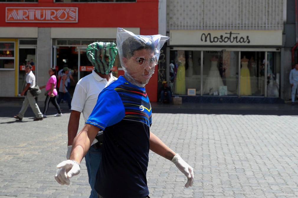 Венесуэла пойтахти Каракасда коронавирусдан ҳимояланиш учун полиэтилен пакетни кийиб олган эркак.