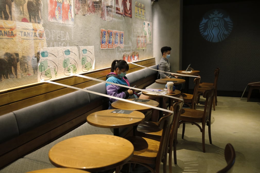 Гонконгдаги Starbucks кафесида одамлар масофа сақлаши учун баъзи столларни лента тортиб ажратиб қўйишган.