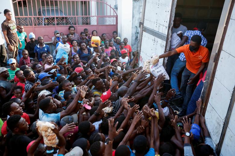 Гаити пойтахти Порт-о-Пренсда юк машинасидан одамларга озиқ-овқат маҳсулотлари тарқатилмоқда.