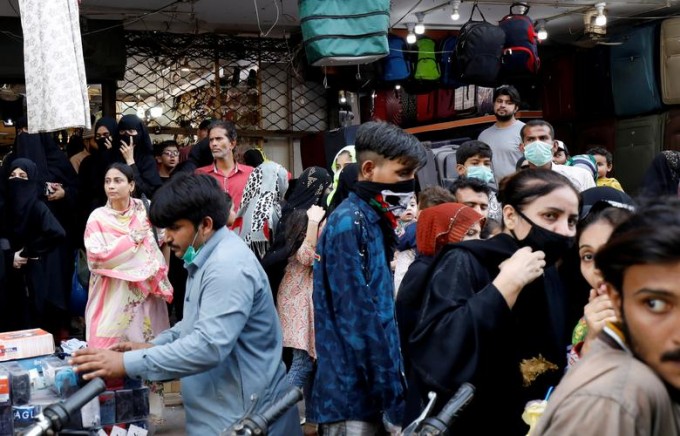 Покистоннинг Карачи шаҳрида полиция томонидан ижтимоий масофа сақламаган одамлар сабаб ёпилган савдо бозори олдида йиғилган оломон.