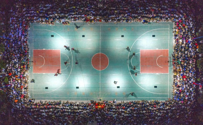 Хитойнинг Шаньси провинциясида баскетбол ўйинини томоша қилаётган қишлоқ аҳолиси.