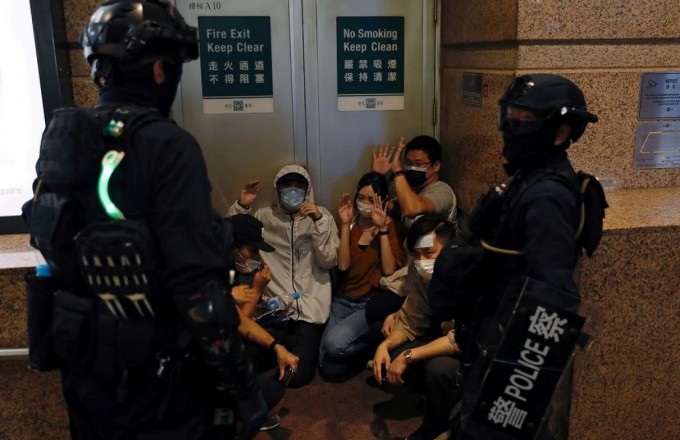 Гонконгдаги кварталлардан бирида намойишчиларни блоклаб қўйган полиция вакиллари.