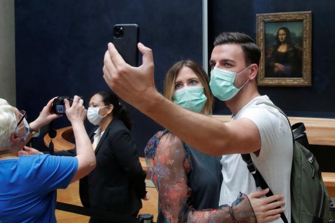 Парижнинг Лувр музейидаги «Мона Лиза» асари олдида селфи қилаётган ташриф буюрувчилар.