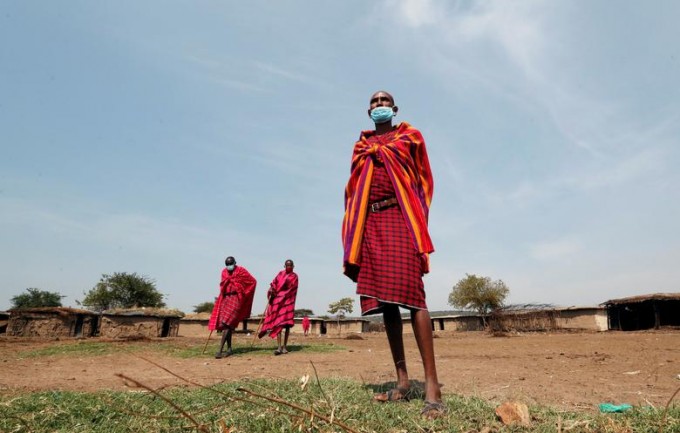 Масаи оқсоқоллари, анъанавий либосларида, юзларида ниқоб билан Кениянинг Нарок туманидаги Masai Mara ов қўриқхонаси яқинида туришибди.
