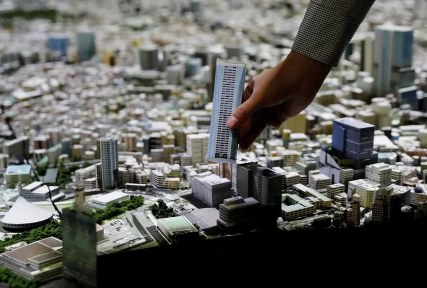 Япониядаги Mori City лабораторияси ходими Токионинг 1:1000 масштабли моделига янги бино макетини қўшмоқда.