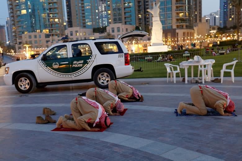 Бирлашган Араб Амирликлари полицияси аъзолари Дубайдаги савдо мажмуаси олдида ифторликдан кейин намоз ўқимоқда.
