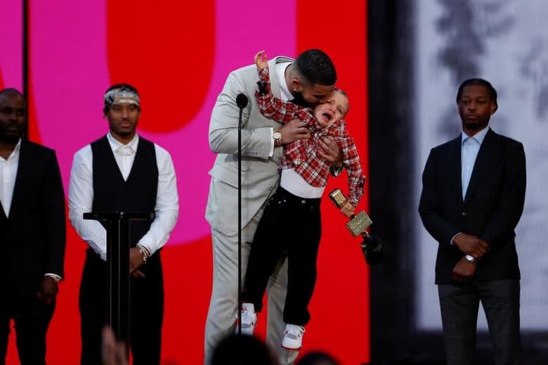 Лос-Анжелесда ўғли Адонис ҳамроҳлигида Billboard Music Awards мукофотини қабул қилаётган қўшиқчи Дрейк.