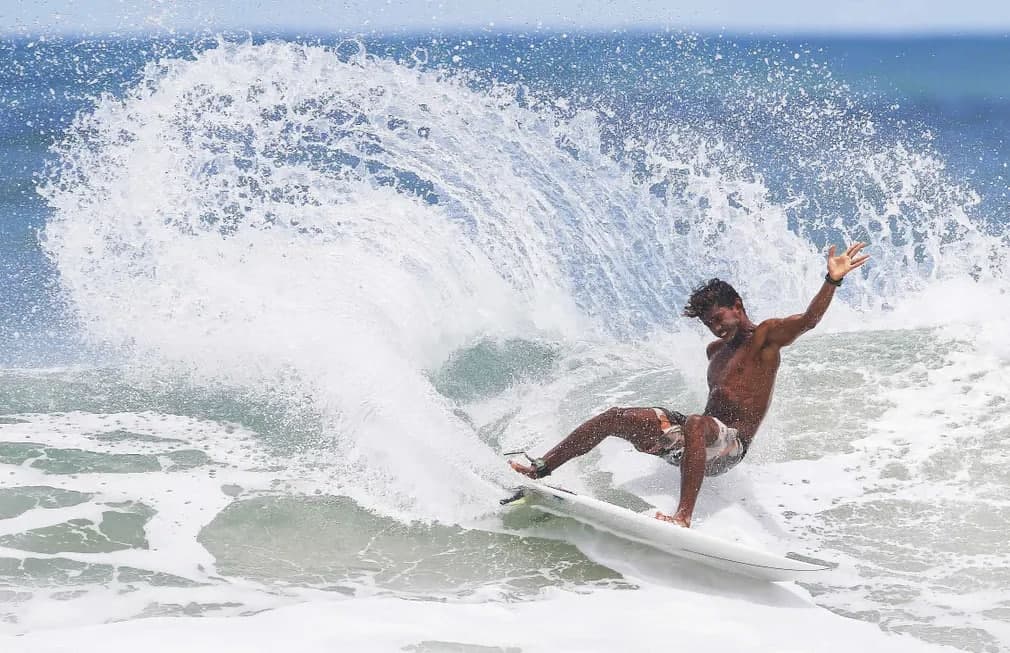 Коста-Риканинг Гуанакасте провинциясидаги Гарза пляжида сёрфинг билан шуғулланаётган йигит.
