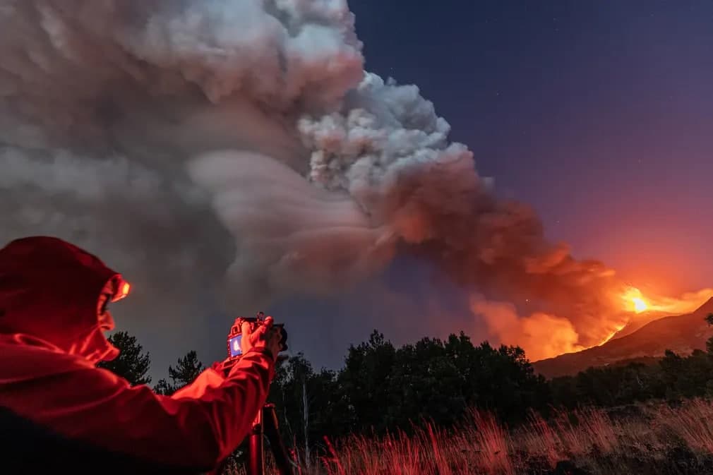 Сицилиядаги Этна вулқони отилишини суратга олаётган фотосуратчи.