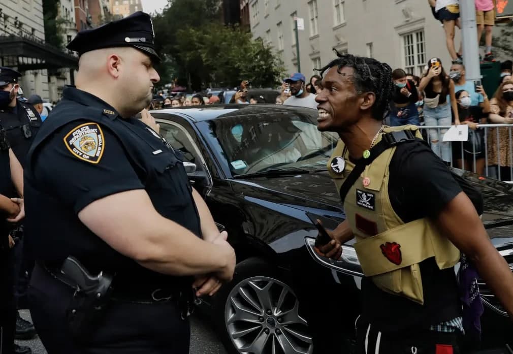 Нью-Йоркдаги Костюм санъати институтининг анъанавий бали бўлиб ўтаётган кўчада полиция ходимлари билан тўқнаш келган Black Lives Matter намойишчиси.