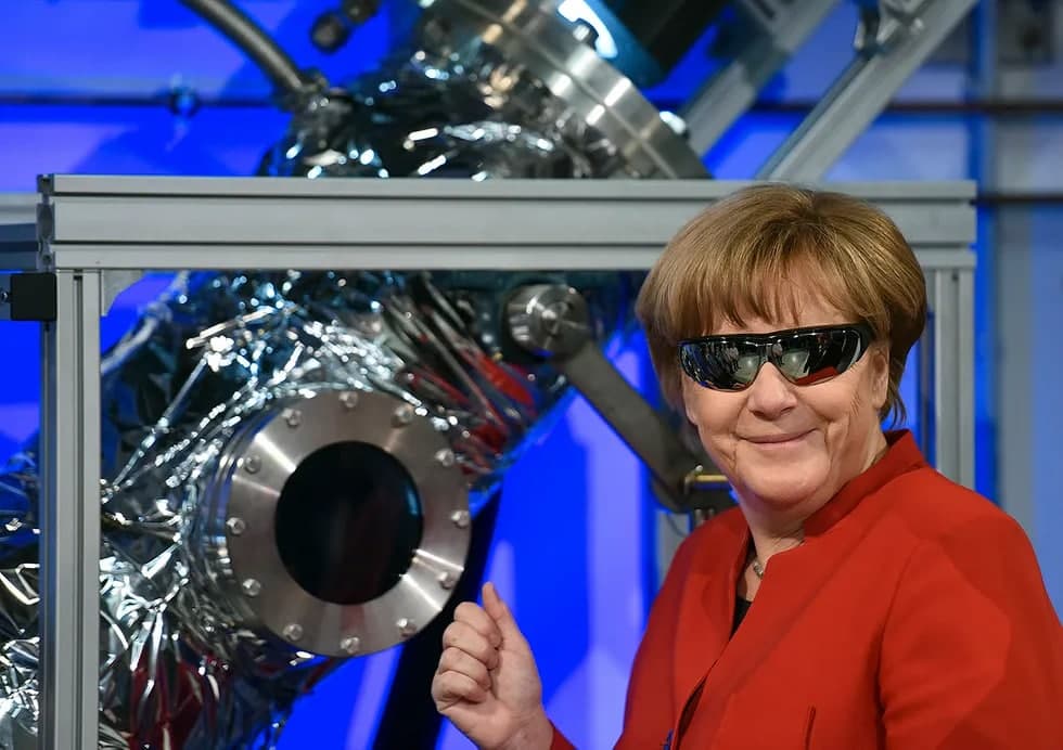 Махсус кўзойнак таққан Ангела Меркель астронавтларни тайёрлаш бўйича Европа марказига ташрифи чоғида. Кёльн, 2016 йил 18 –май