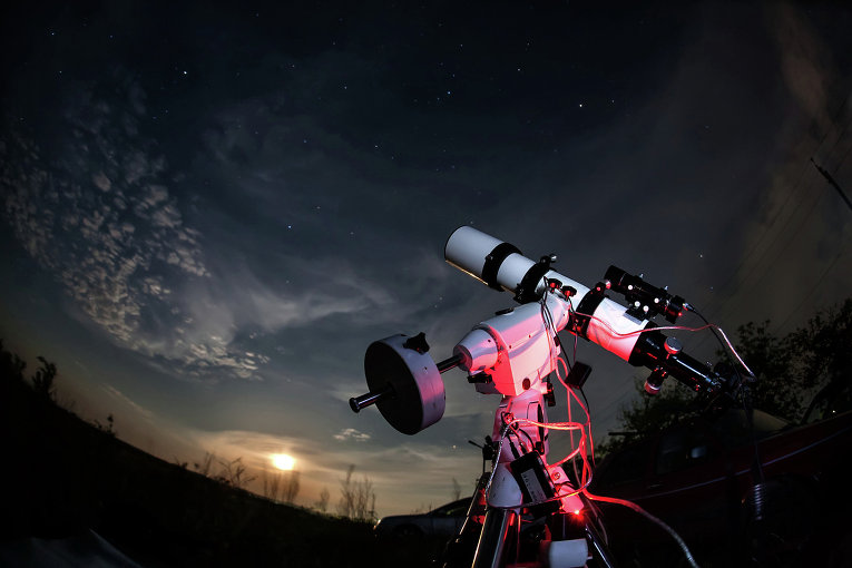 Yulduzli osmon fonidagi teleskop. Foto: Fotolia