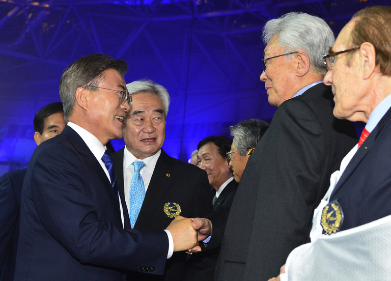 Janubiy Koreya prezidenti Chje In Mun (chapda) Mujudagi musobaqa ochilishda Shimoliy Koreya delegatsiyasi vakillari bilan ko‘rishmoqda.