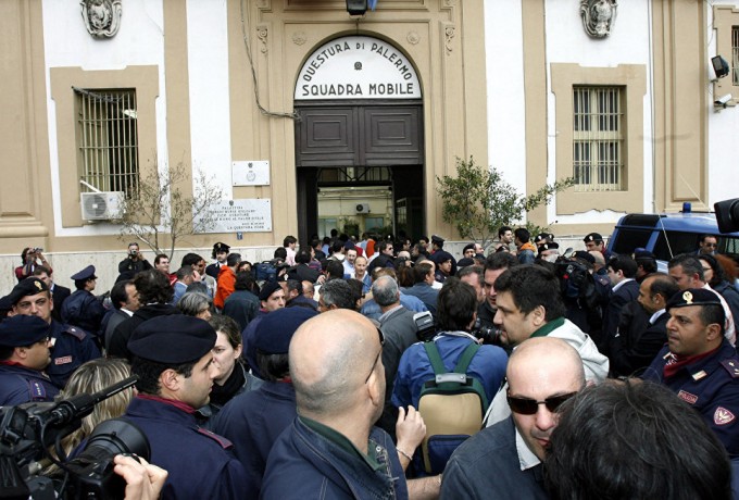 Politsiya va mahalliy aholi mafiya boshlig‘i Bernardino Provensano keltirilgan bino yonida, Palermo, Italiya. 2006-yil 11-aprel. Foto: AP Photo