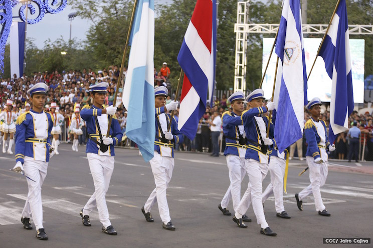 Ҳарбийлар парадда Гватемала, Коста-Рика, Никарагуа ва Гондурас байроқларини олиб ўтмоқда.