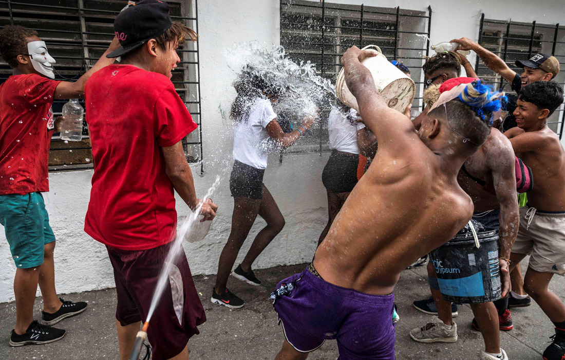 Venesueladagi karnaval doirasidagi sayilda qizlarga suv sepayotgan o‘g‘il bolalar.