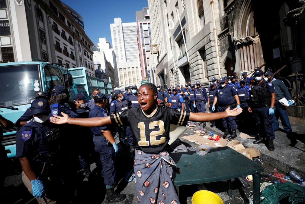 ЖАРнинг Кейптаун шаҳрида черковни эгаллаб олган қочоқларни тарқатиш учун келган полиция қаршисида йиғлаётган аёл.