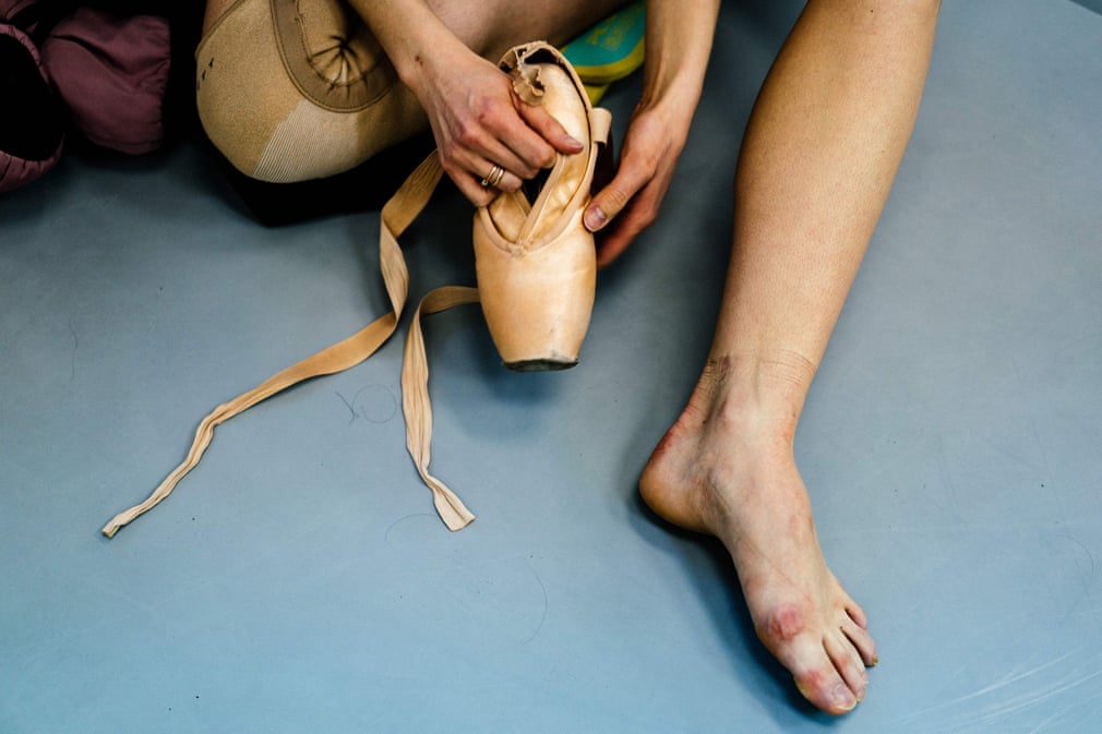 Balet raqqosasi Aleksandra Kirshina “Grishko” kompaniyasi tomonidan uning uchun maxsus tikilgan balet raqqosalari oyoq kiyimini ushlab o‘tiribdi.