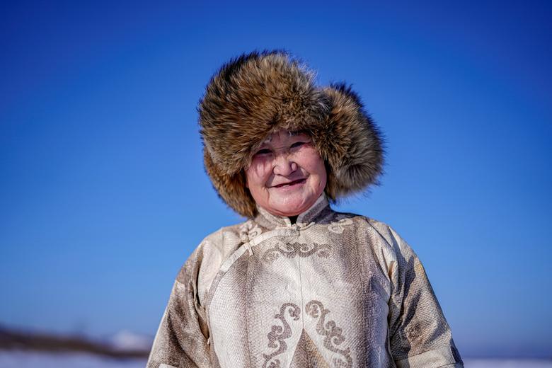 Xechjen etnik guruhidan 68 yoshli Yu Venfen baliq terisidan tikilgan kiyimida Xitoydagi muzlagan Tunszyan ko‘li ustida suratga tushmoqda. Venfen baliq terisidan kiyim tika oladigan kam sonli odamlardan biri hisoblanadi. <em>2020-yil, 1-yanvar.</em>