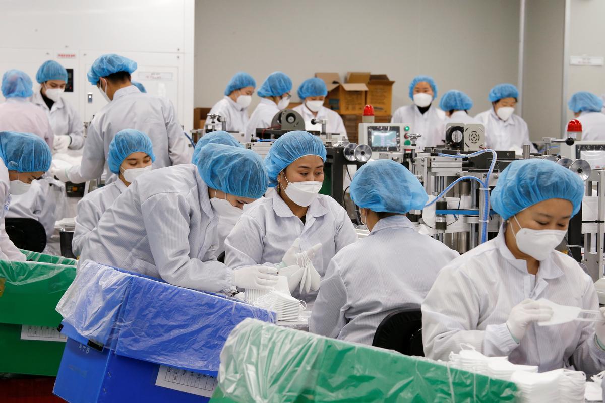 Janubiy Koreyaning Inchxon shahridagi fabrikada ishchilar tibbiyot niqoblarini tikmoqda.