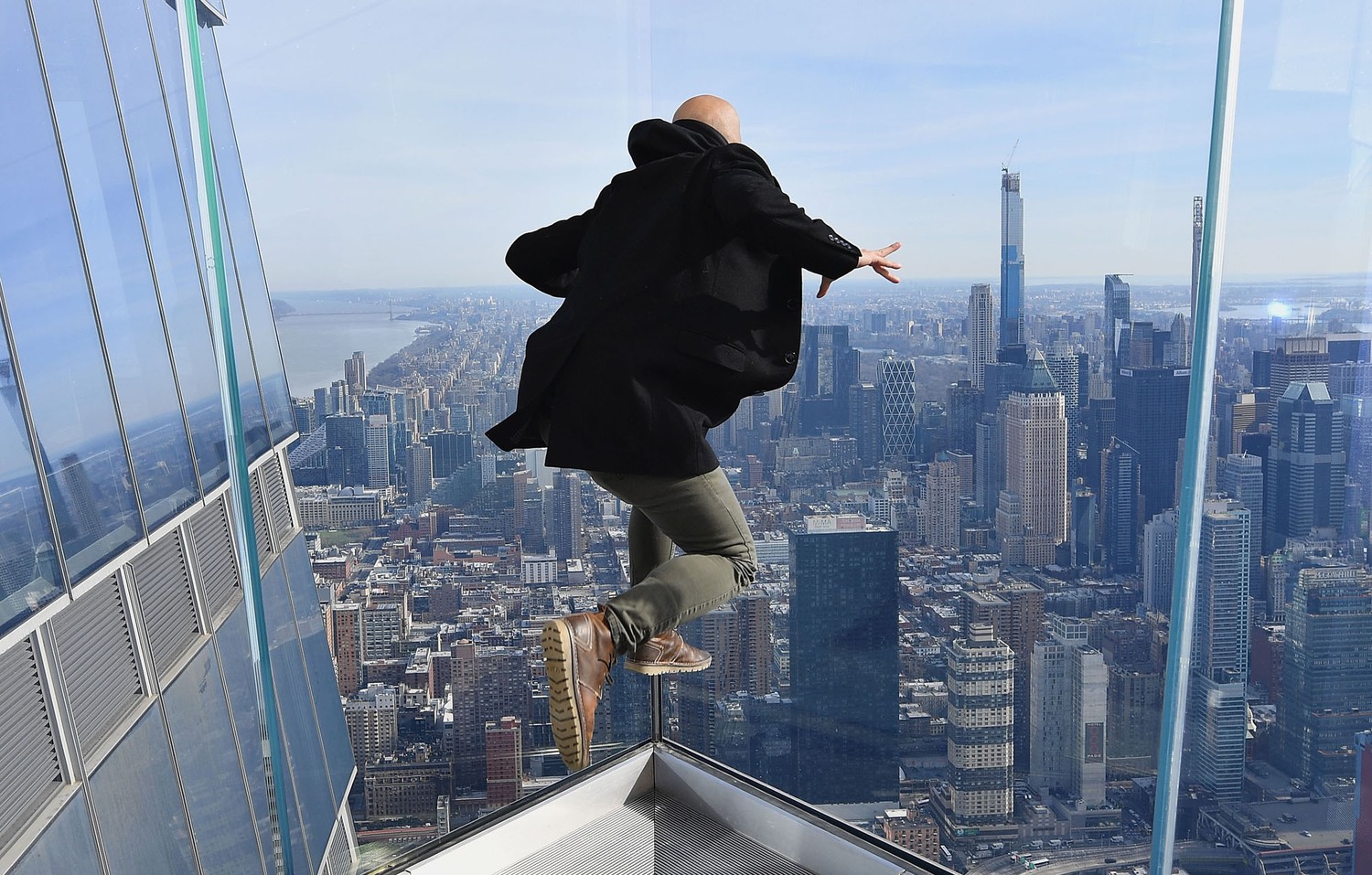Нью-Йоркда Ғарбий яримшардаги энг баланд кузатув майдончасида сакраётган эркак. Hudson Yards Tower’нинг 100-қаватидаги The Edge кузатув майдончаси 335 метр баландликда жойлашган.