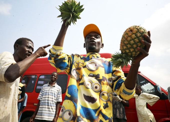 Nigeriya poytaxti Abujada ananas sotuvchisi xaridorlarni o‘z rastasiga chorlamoqda.