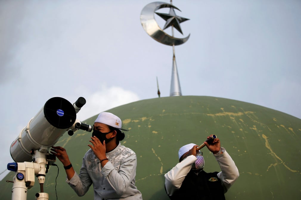 Jakartadagi Al-Musariin masjidi tomidagi talabalar teleskop va monokl yordamida oyning chiqishini kuzatmoqda.