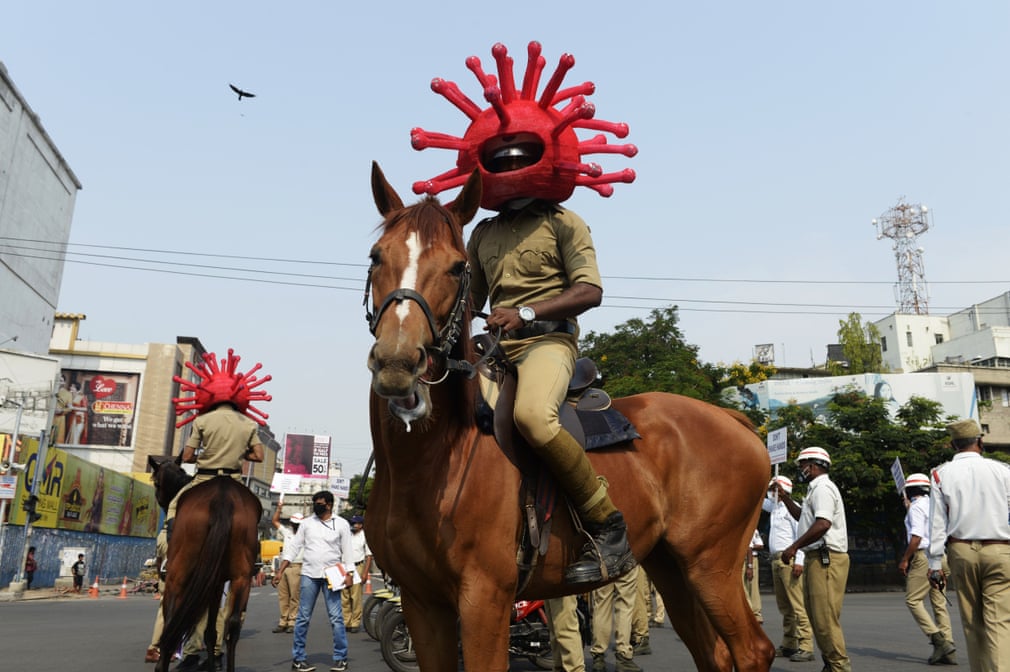 Ҳиндистонда коронавирусли шлем кийиб олган отлиқ полициячи.