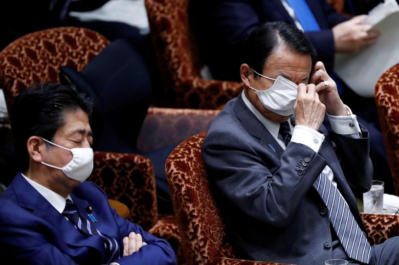 Tokioda parlament sessiyasida Yaponiya bosh vaziri Sindzo Abe oldida o‘tirgan moliya vaziri Taro Aso tibbiyot niqobini tuzatib olmoqda.