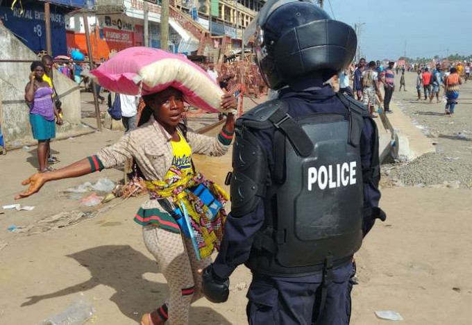 Либерия пойтахти Монровия шаҳрида полиция ходими Қизил фонарлар номли бозорни харидорлар оқимидан тозаламоқда.