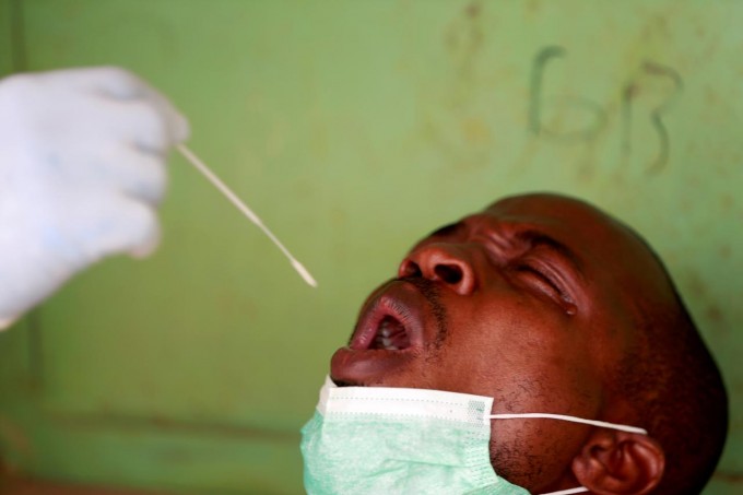 Nigeriya poytaxti Abudja shahrida koronavirus infeksiyasini aniqlash uchun test topshirayotgan erkak.