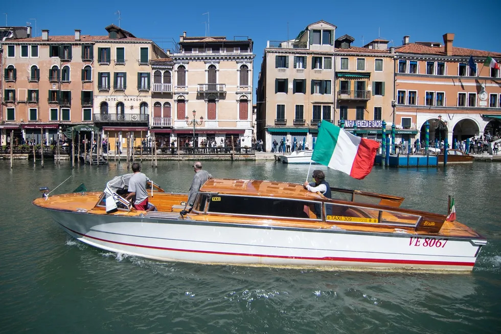 Венецияда сув таксиси ҳайдовчиси бизнесларнинг ишни қайта тиклашини талаб қилувчи норозилик акциясида.