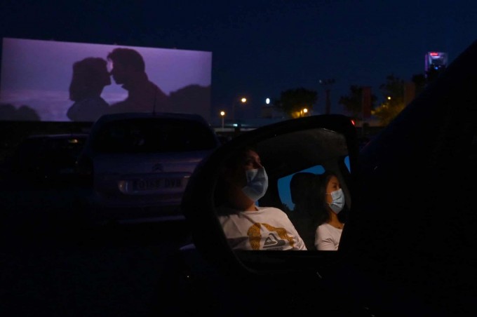 Ispaniyaning Madrid shahridagi ko‘chma kinoteatrda avtomobillarida o‘tirgan holda film ko‘rayotgan odamlar.