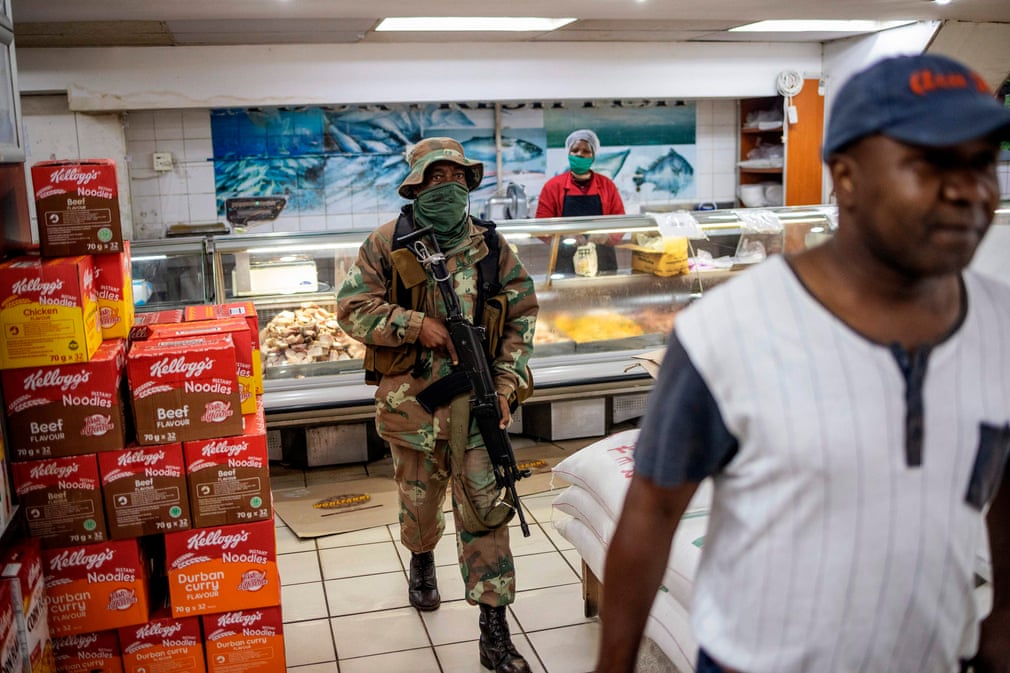 Жанубий Африканинг Йоханнесбург шаҳрида ҳарбий хизматчи супермаркетдаги одамларни тинтув қилмоқда.