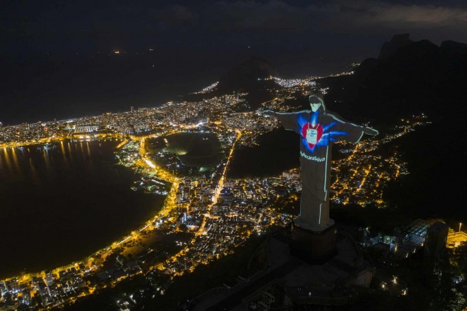 Braziliyaning Rio-de-Janeyro shahridagi Iso Masih haykalida “niqob qutqaradi” yozuvi va himoya niqobi chiroqlar yordamida aks ettirilgan.