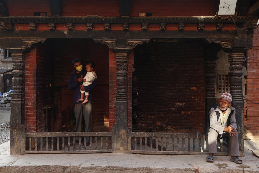 Nepalning Bxatkapur shahridagi kichik ibodatxonada ota o‘z o‘g‘liga gul bermoqda.