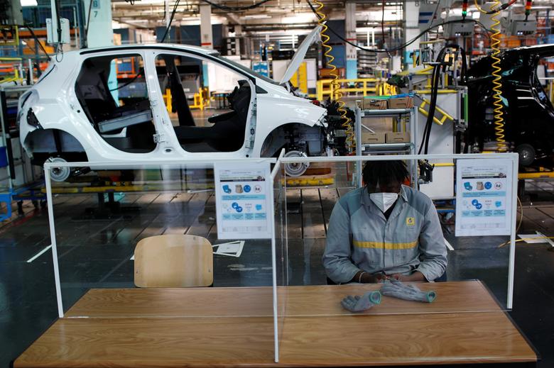 Франциядаги Renault заводи ишчиси юзига ниқоб таққан ҳолда автомобиллар йиғиладиган конвейерда ўтирибди.