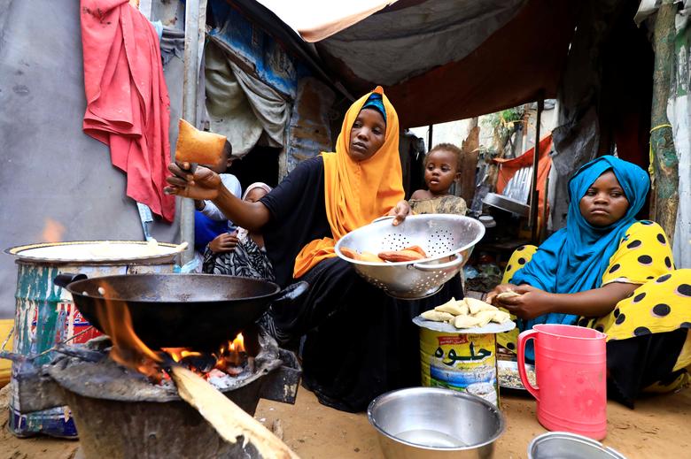 Сомалида аёл ўз фарзандлари билан биргаликда ифторлик тайёрламоқда.