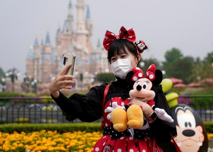 Хитойда қайта очилган Шанхай Disney боғида селфи тушаётган ташриф буюрувчи.
