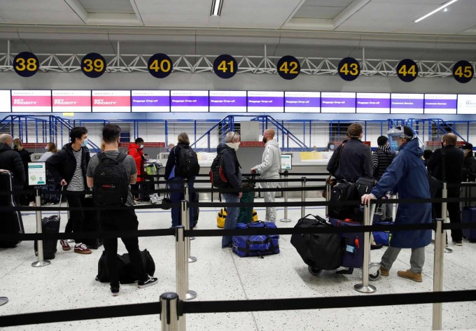 Angliyaning Manchester shahrida yo‘lovchilar aeroportda navbatda turibdi. Koronavirus sababli karantin tartibi yumshatildi.