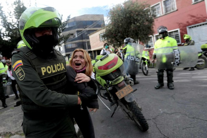 Kolumbiyaning Bogota shahrida fuqarolik huquqlari uchun aksiyaga chiqqan ayol politsiya tomonidan ushlab olib ketilmoqda.