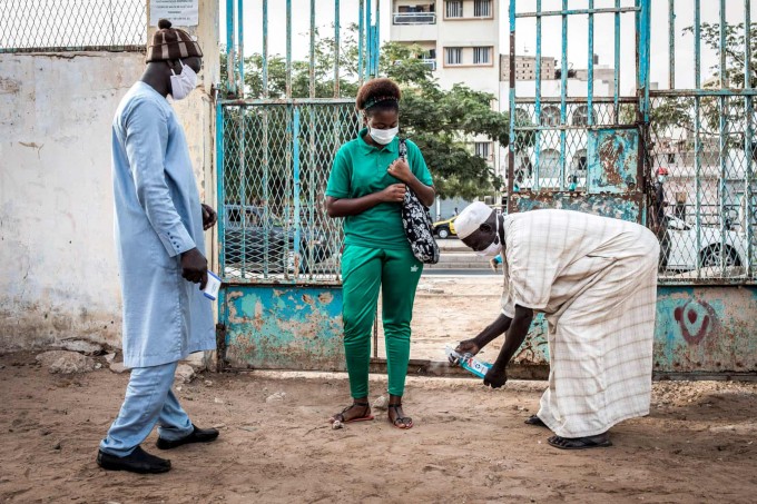 Senegalning Dakar shahrida litseyning yuqori sinf o‘quvchilari kirish yo‘lagida dezinfeksiya qilinmoqda.