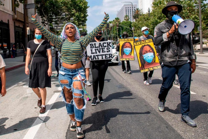 AQShning Los-Anjeles shahri markazida Black Lives Matter aksiyasi qatnashchilari boshqa namoyishchilar bilan birga harakatlanib bormoqda.