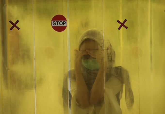 Indoneziyaning Jakarta shahrida savdo markaziga kirish oldidan dezinfeksiyadan o‘tayotgan ayol.