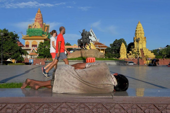 Kambodjaning Pnompen shahrida yerda yotgan boshpanasiz odam.