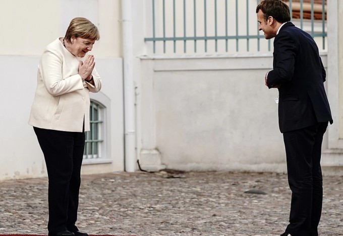 Fransiya prezidenti Emmanuel Makron rasmiy tashrif bilan Germaniyaga kelgan chog‘ida Angela Merkel uni masofa saqlagan holda qutlamoqda.