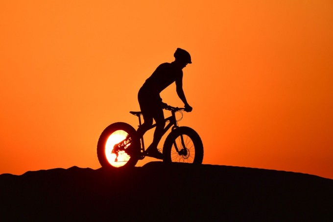 Dubay shahridagi Al-Qudra cho‘lida ketayotgan velosipedchi.