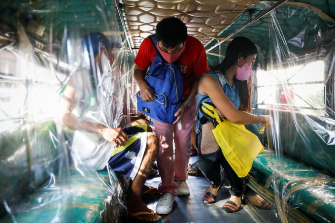 Filippinning Manila shahridagi Keson Siti hududida yo‘lovchilar mikrobusga chiqmoqda.