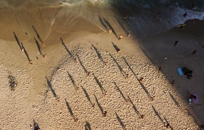 Бразилиянинг Рио-де-Жанейро шаҳридаги Копакабана пляжида тўп ўйнаётган одамлар.