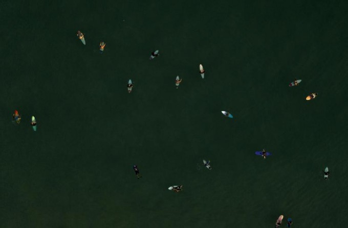 Бразилиянинг Рио-де-Жанейро шаҳридаги Ипанема пляжида тўлқинлар келишини кутаётган сёрферлар.